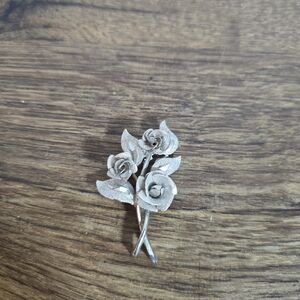 brooch is a vintage silver-tone textured rose and leaf pin